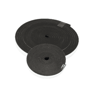 The Rubber Gasket Kit for Trapzilla Lids includes two coiled black foam rolls with white adhesive backing, ideal for sealing around grease interceptors in restaurants. Each roll is secured with clear tape.