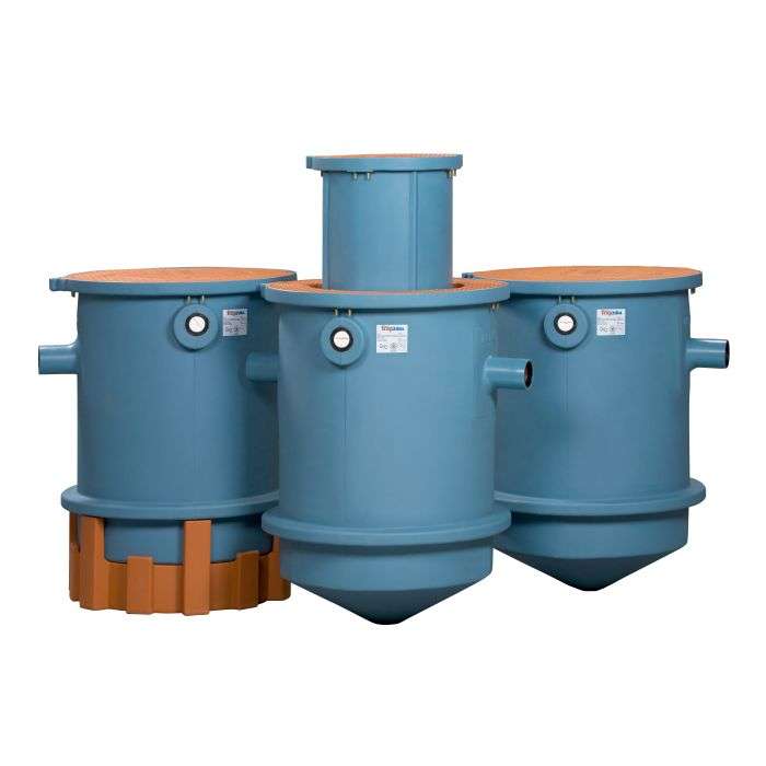 Three large blue cylindrical TZ-600 Trapzilla Grease Interceptors with orange lids and bases are positioned side by side, each featuring pipe connections and front identification labels—ideal for super-capacity grease removal in restaurants.